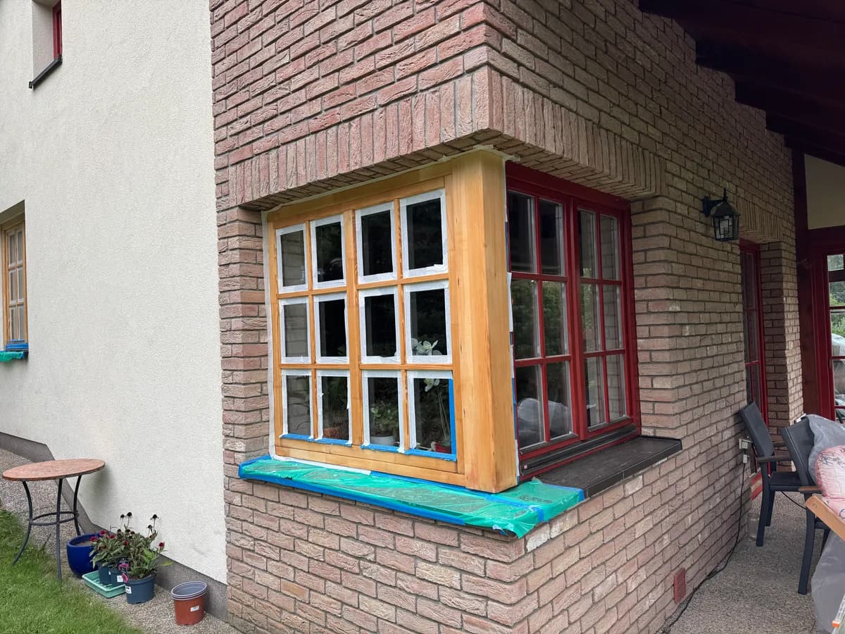 Stejná okna během renovace, rám obroušený na holé dřevo